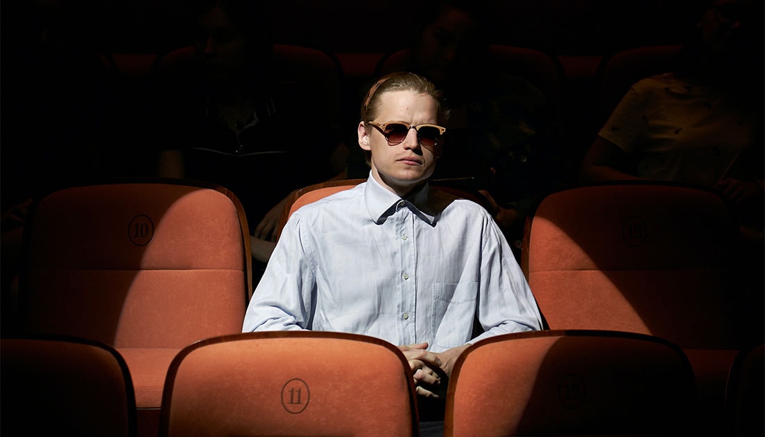 man sitting in cinema with the spotlight on him